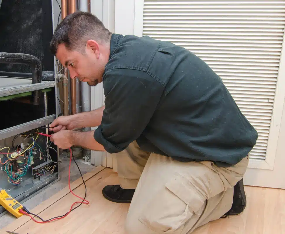 Technician checks HVAC system temperature with a multimeter